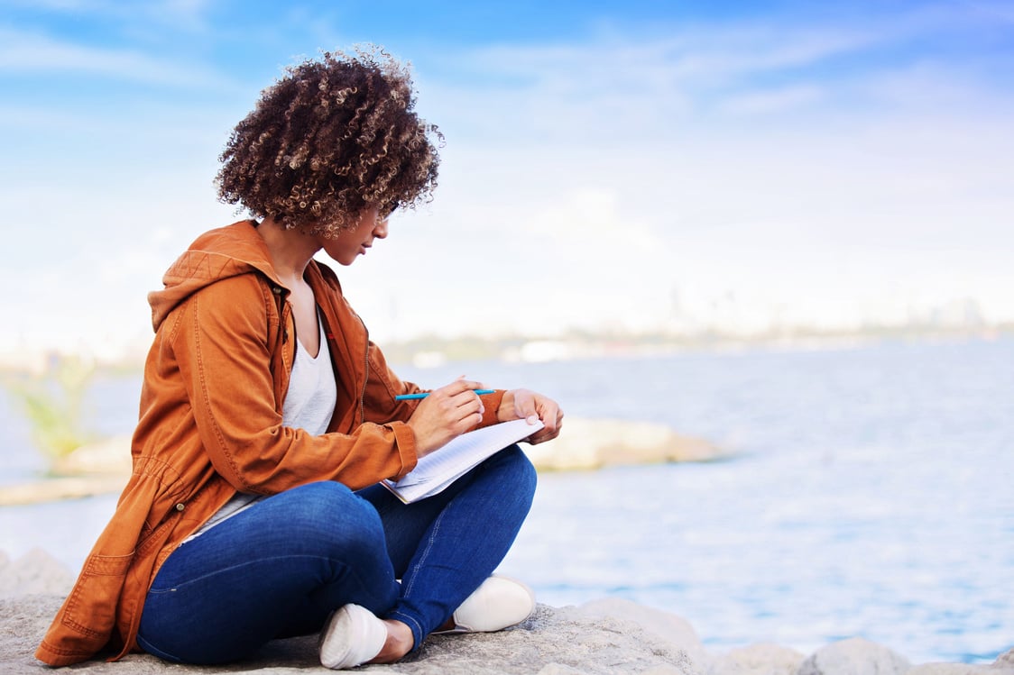 Woman Writing in a Notebook Outdoors